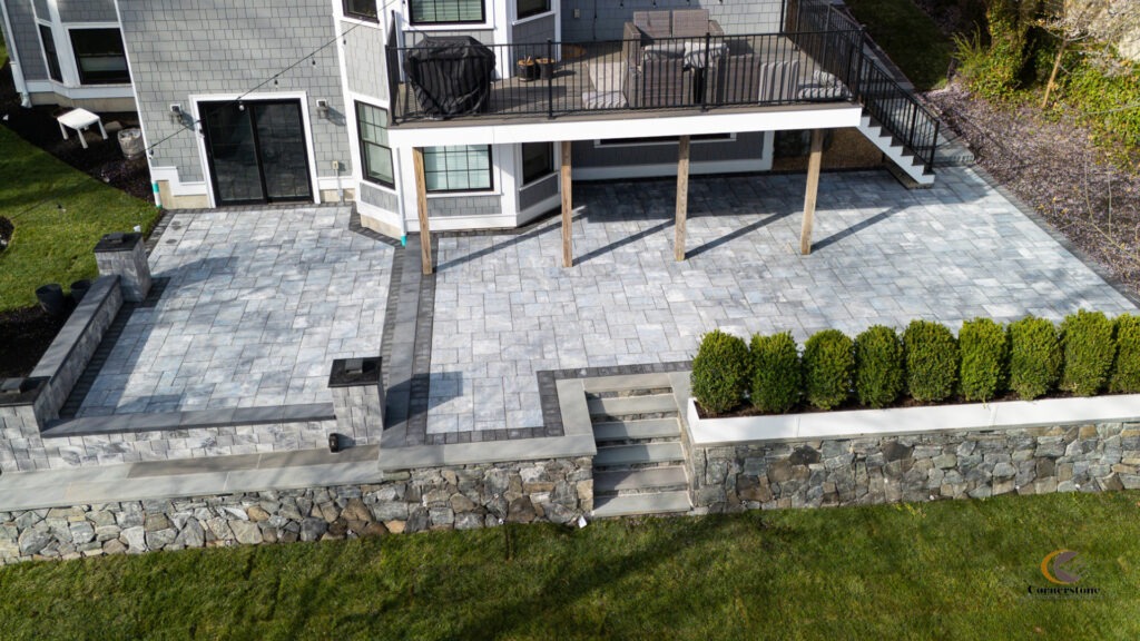 A stunning photo of a backyard patio with retaining wall and concrete pavers