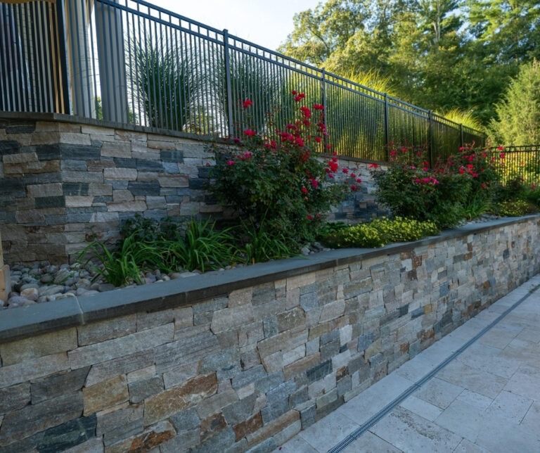 Retaining wall with New England Blend stone veneers in Hopkinton backyard project supplied by Cornerstone Landscape Supplies.