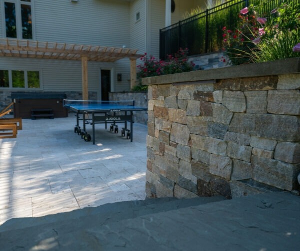 New England Blend stone veneer wall with Bluestone tread cap in Hopkinton backyard project by Elite Stoneworks using materials from Cornerstone Landscape Supplies