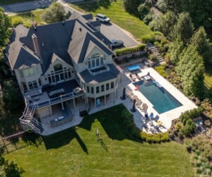 Backyard transformation in Hopkinton, MA featuring Walnut French Pattern Travertine pool deck and outdoor living space by Elite Stoneworks with materials from Cornerstone Landscape Supplies.
