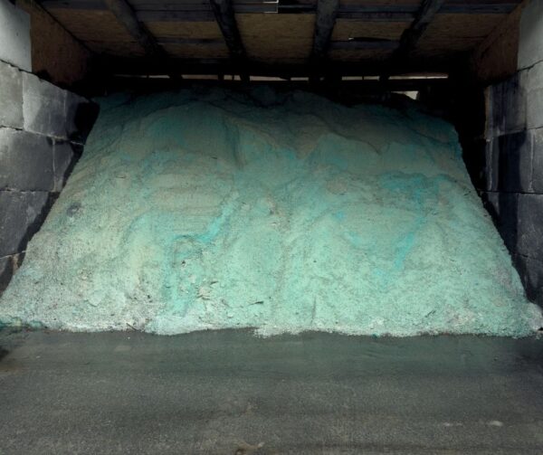 Snow plow spreading treated road salt